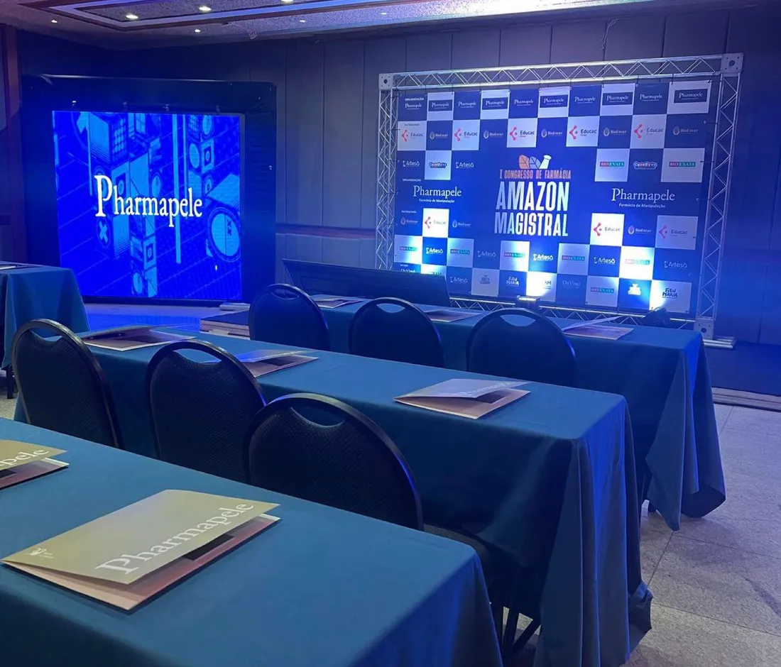 Sala de congresso montada, com painel de patrocinadores