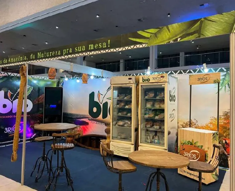 Stand com geladeiras de produto e mesas em uma feira