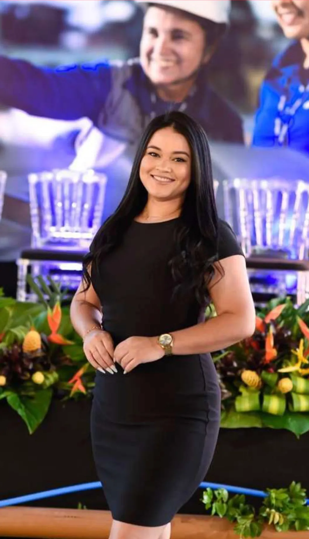 Recepcionista em frente à mesa de um evento corporativo