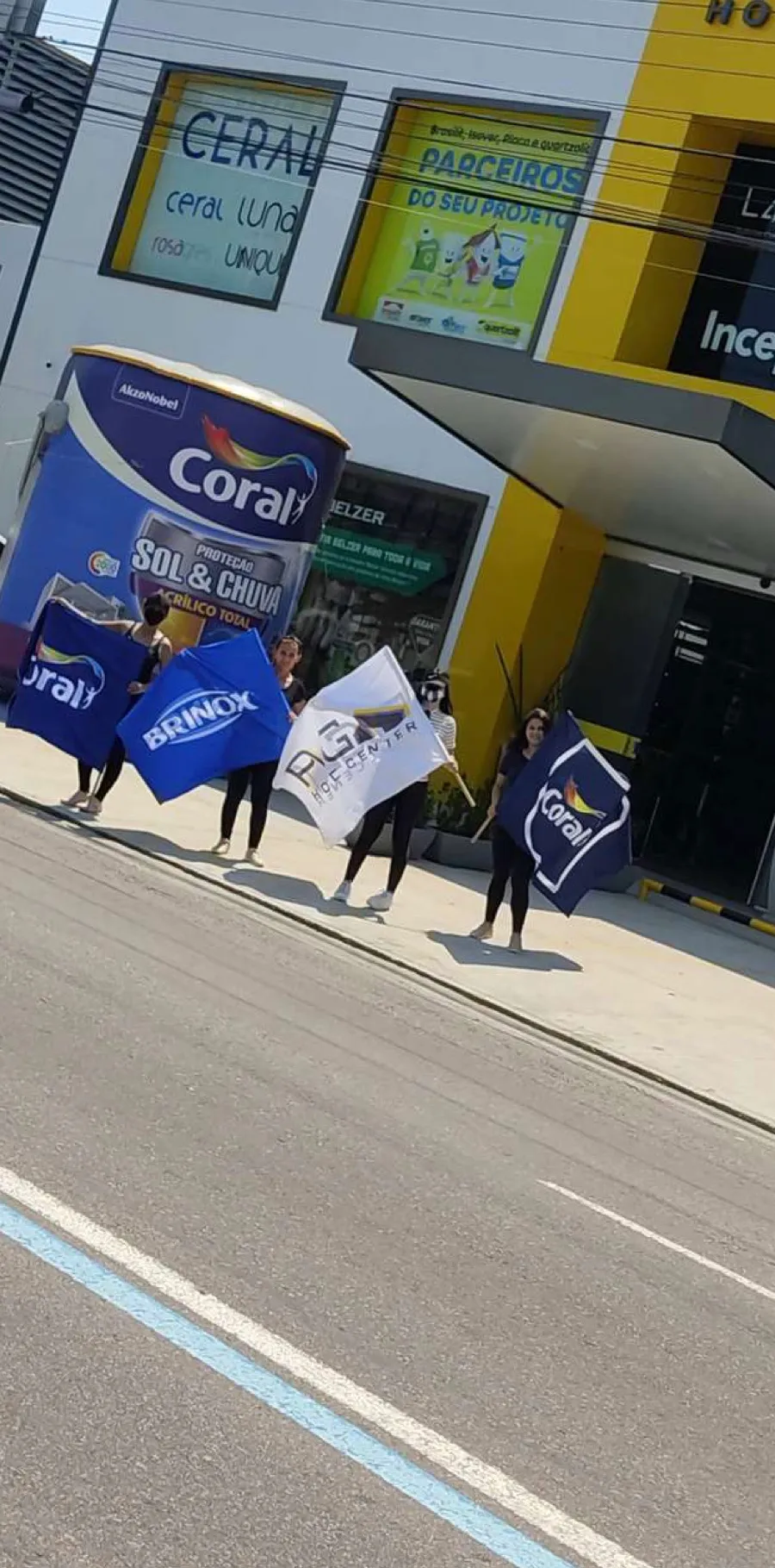 Equipe com bandeiras da marca em frente à loja